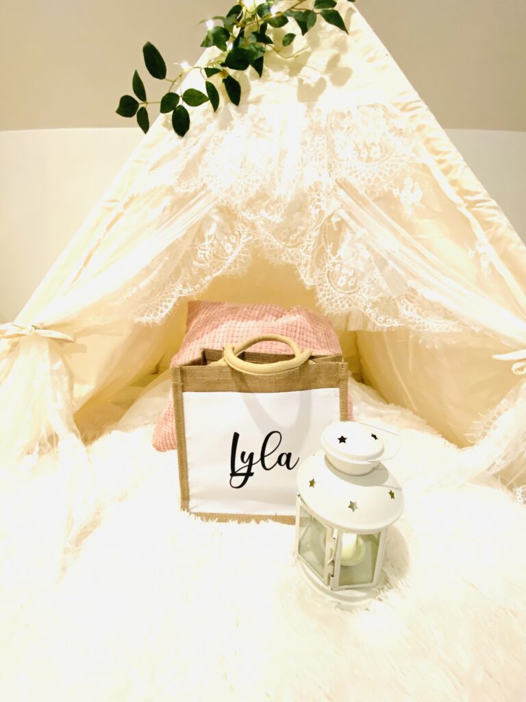 closeup tent with lace roof and gingham pillows with personalized bag