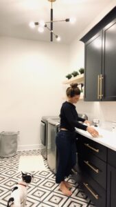 black cabinets in laundry room with woman