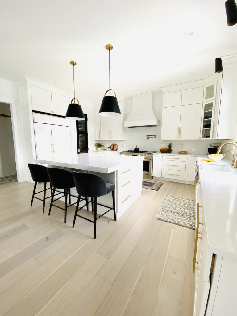 white and black themed kitchen with hanging lamps