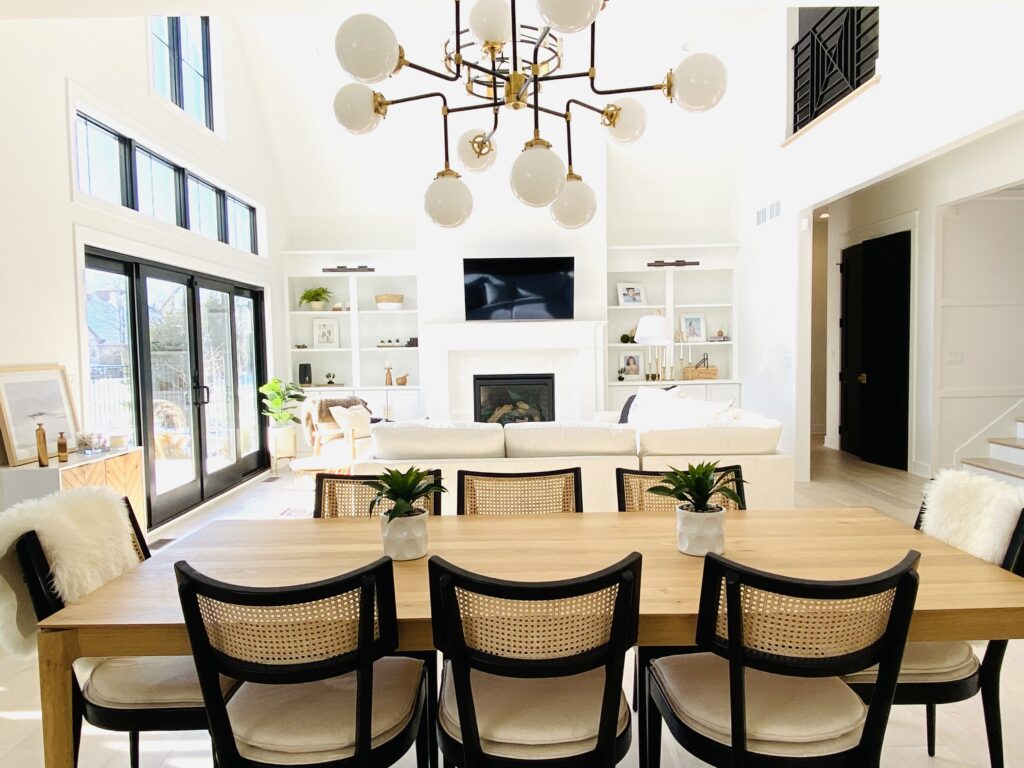 wide table with chairs and chandelier in living room with fireplace