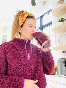 woman wearing a bandana drinking a smoothie