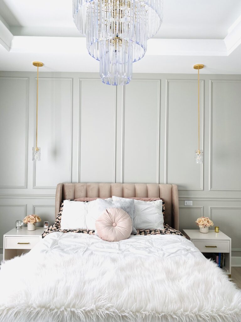 princess style bed with glass chandelier and white end tables