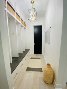 thumbnail hallway with chandelier black door and empty cabinet shelves