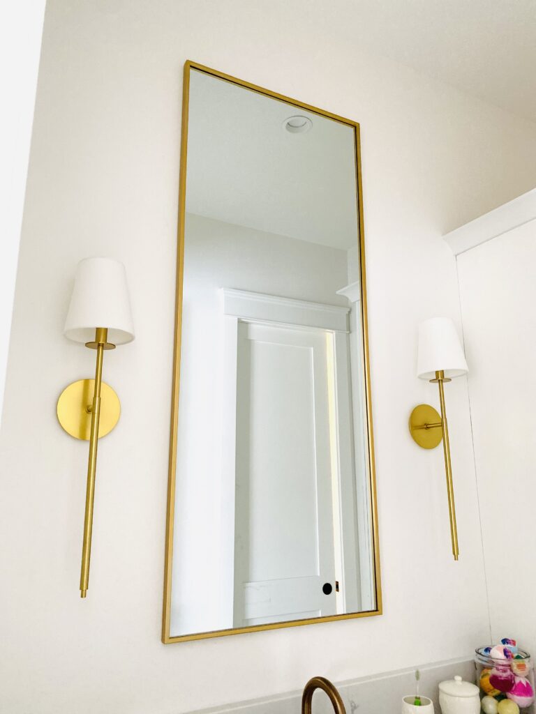 gold rectangular mirror with gold tipped lamps