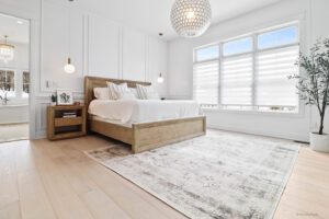 large bedroom with wooden side table and large rug