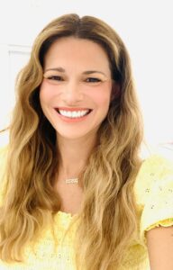 woman wearing a yellow top with wavy blonde hair