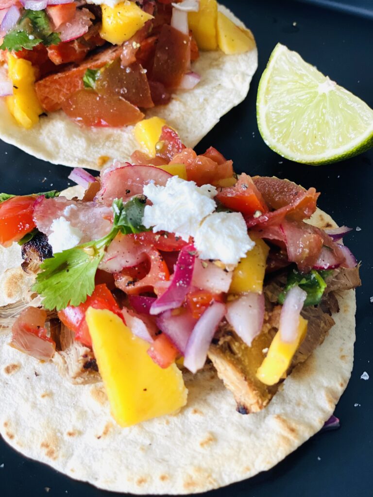 open-faced tacos with vegetables and lime wedge