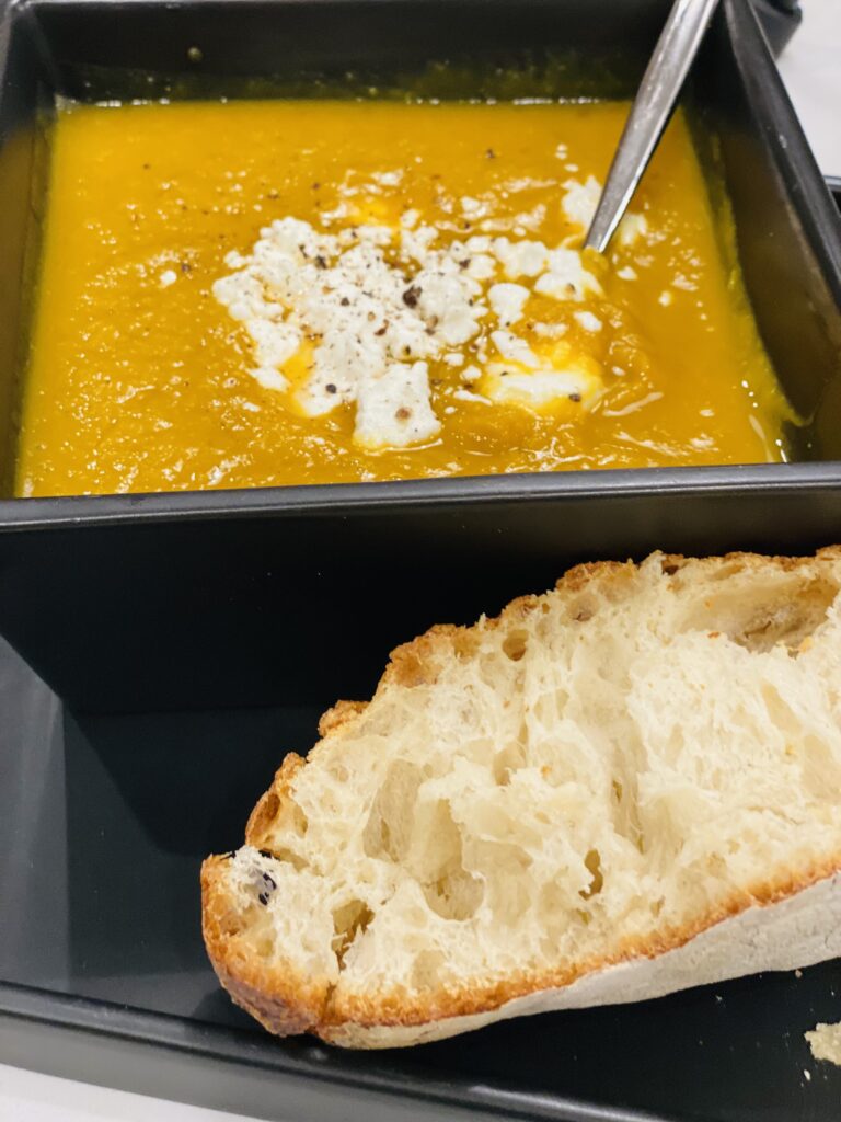 closeup of squash soup with cheese and toasted bread