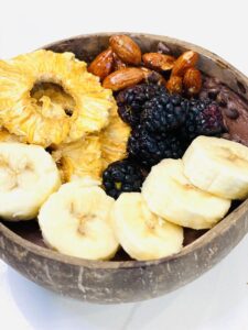 bowl of bananas pineapples almonds and blackberries