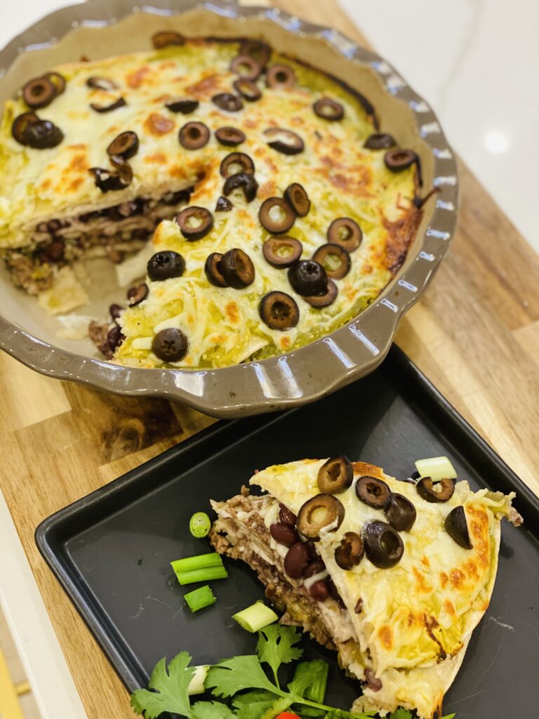 Quiche with black olives and vegetables on a tray